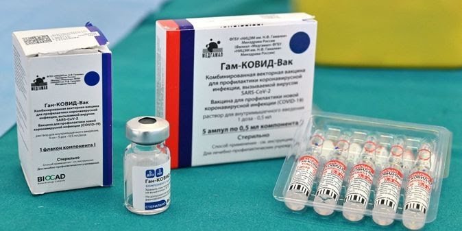 Deux boites de vaccin Spoutnik V COVID-19, un flacon unique et un bac en plastique contenant cinq flacons du même vaccin.